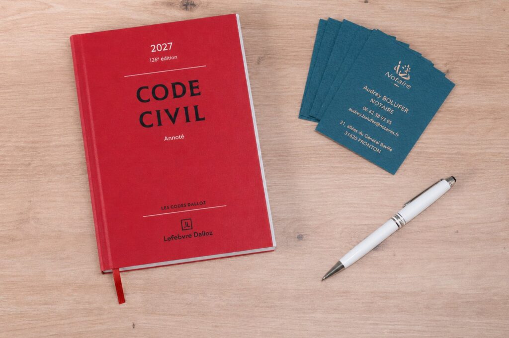 Code civil posé sur le bureau de l’étude, à côté des cartes de visite de Maître Bolufer