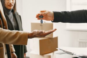 Une main age remet un jeu de cles de maison dans la main d'une personne plus jeune